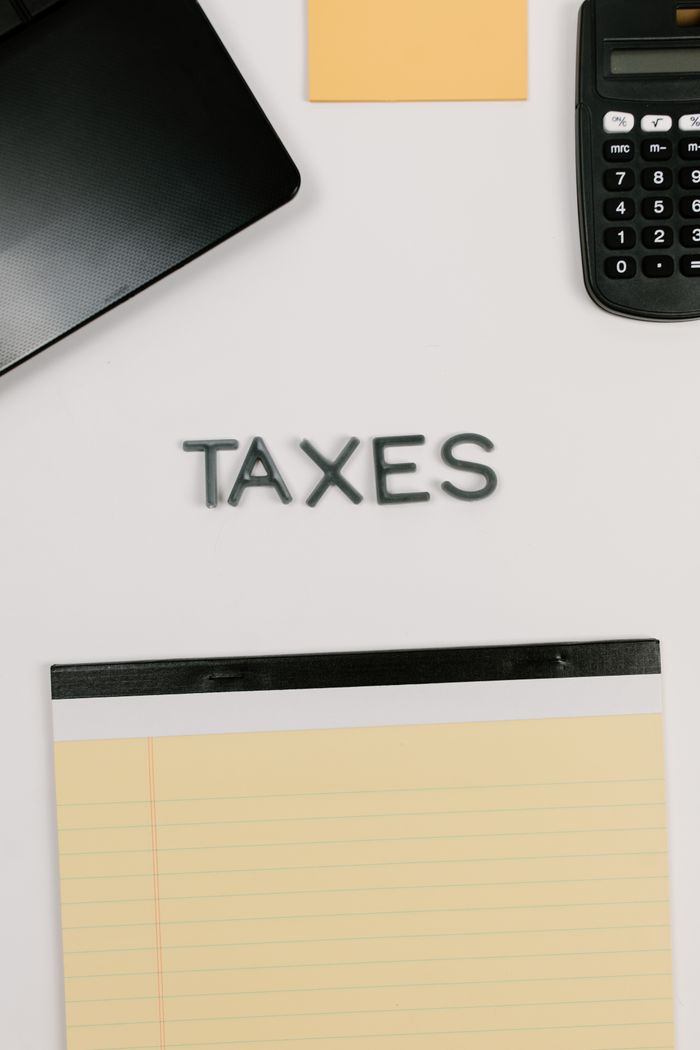 About Top view of office supplies including calculator and notepad for taxes.