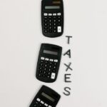 Flat lay of three calculators with 'TAXES' text on a white background.